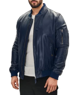 Right side perspective of men's blue genuine leather bomber jacket, showcasing zipper details on the sleeve pocket and the jacket’s modern tailored silhouette.