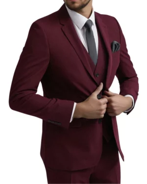 Three-quarter view of a groom-ready burgundy two-button blazer on a male model, showcasing tailored waist tapering and flap pockets